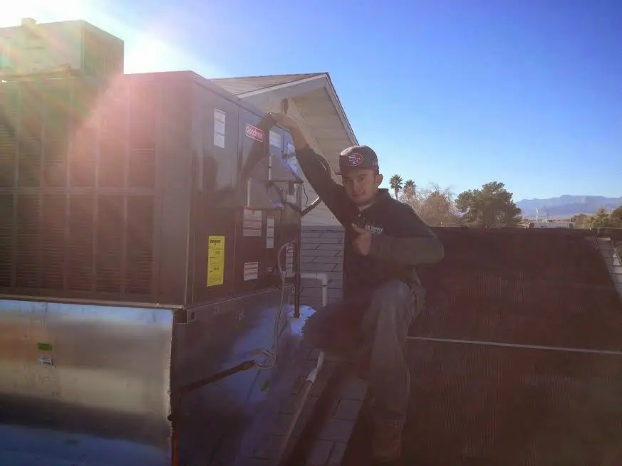 HVAC technician performing Heat Pump Repair on a rooftop unit in Fairfield